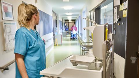 Eine Pflegekraftsteht  auf dem Flur in einem Pflegeheim.