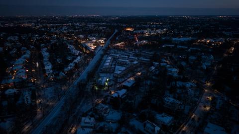 Drohnenansicht von Berlin-Zehlendorf bei Nacht. Zahlreiche Straßen sind komplett dunkel, nur vereinzelt ist Licht zu sehen.