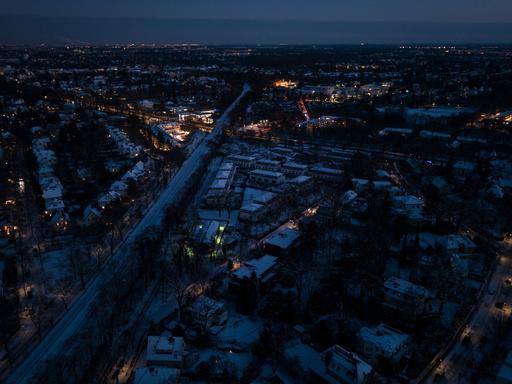 Drohnenansicht von Berlin-Zehlendorf bei Nacht. Zahlreiche Straßen sind komplett dunkel, nur vereinzelt ist Licht zu sehen.