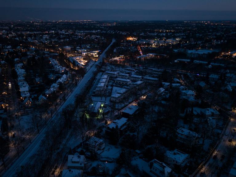 Drohnenansicht von Berlin-Zehlendorf bei Nacht. Zahlreiche Straßen sind komplett dunkel, nur vereinzelt ist Licht zu sehen.