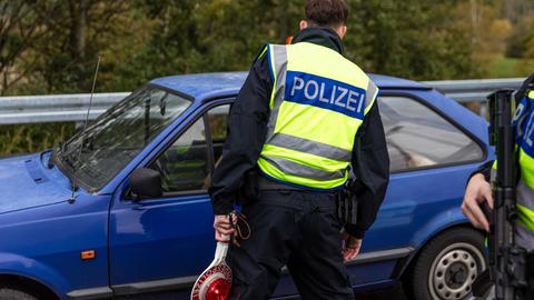 Ein Beamter der Bundespolizei spricht mit dem Fahrer eines Pkw an der Autobahn A15, an der Grenze zwischen Polen und Deutschland.