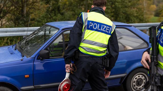 Ein Beamter der Bundespolizei spricht mit dem Fahrer eines Pkw an der Autobahn A15, an der Grenze zwischen Polen und Deutschland