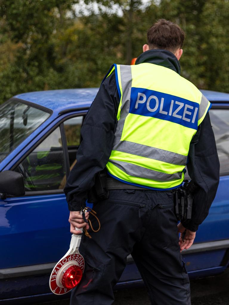 Ein Beamter der Bundespolizei spricht mit dem Fahrer eines Pkw an der Autobahn A15, an der Grenze zwischen Polen und Deutschland