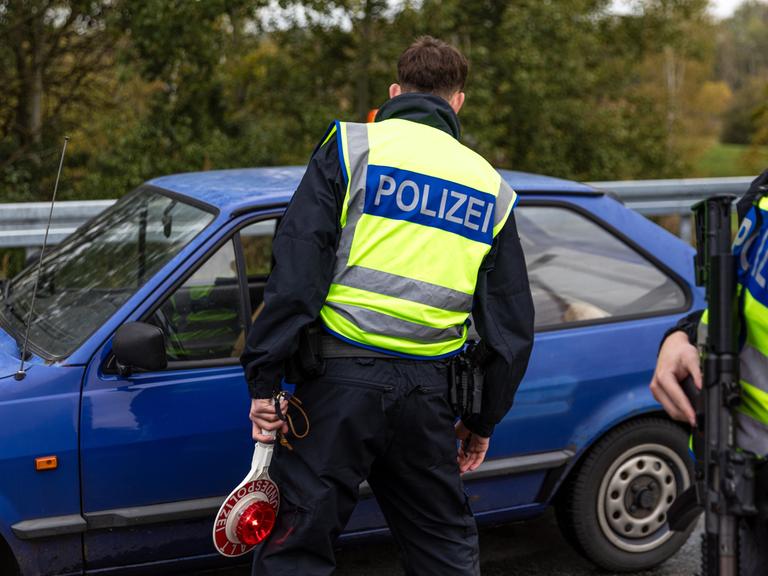 Ein Beamter der Bundespolizei spricht mit dem Fahrer eines Pkw an der Autobahn A15, an der Grenze zwischen Polen und Deutschland