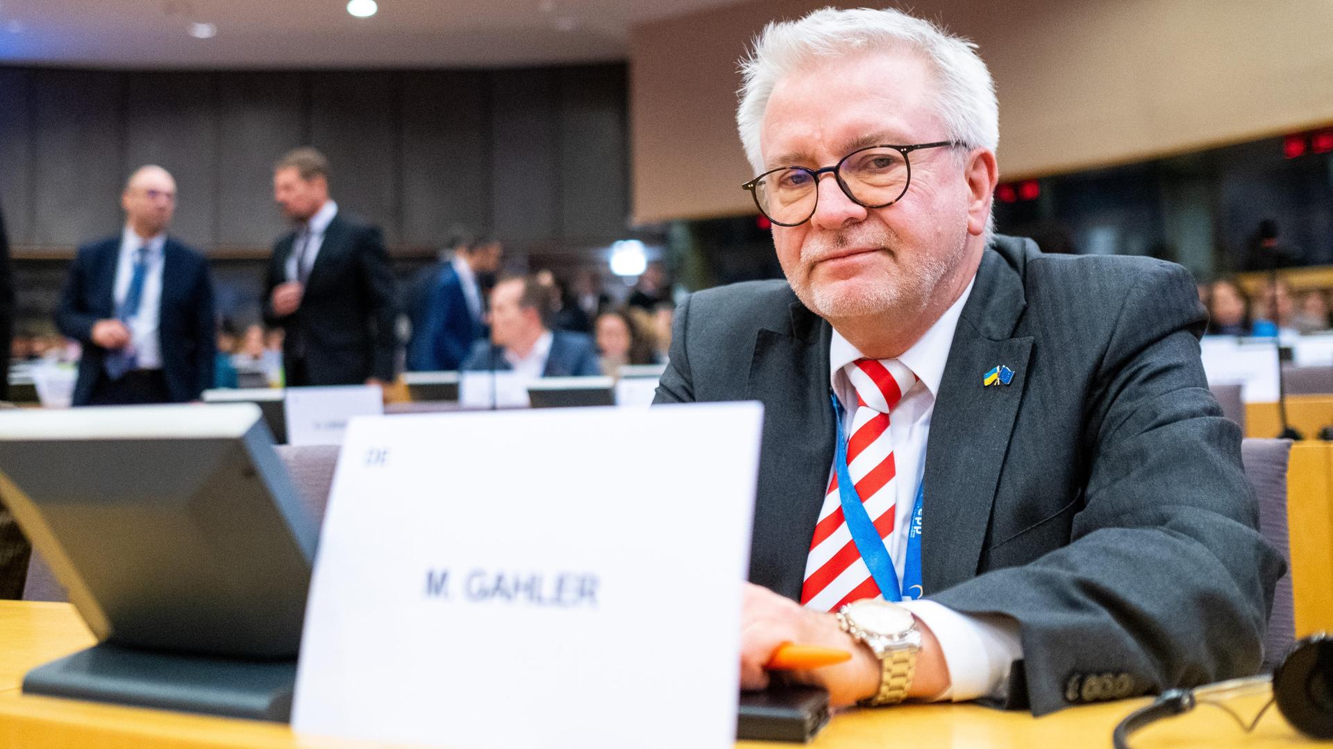 Der CDU-Europaabgeordnete Gahler sitzt in Brüssel im Parlament. Vor ihm steht ein Schild mit seinem Namen.