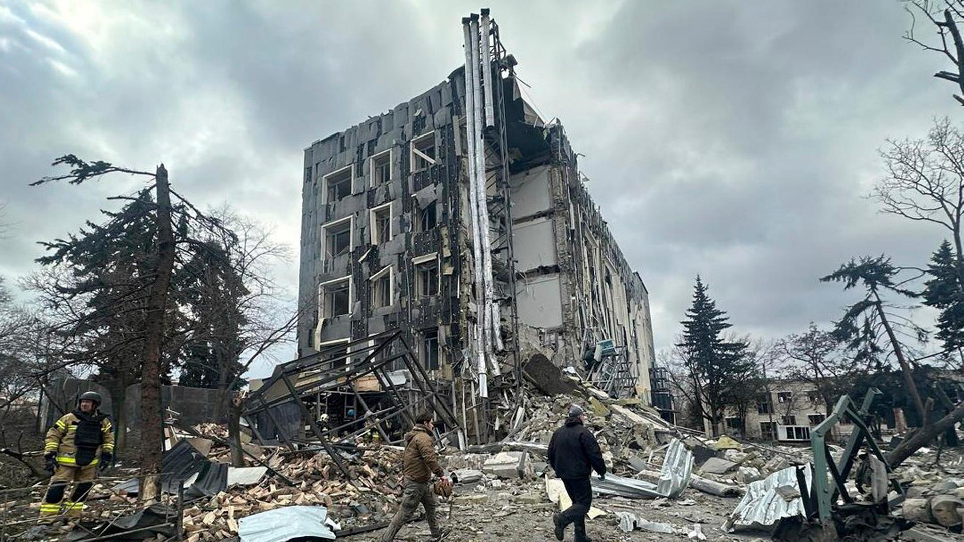 Auf diesem vom ukrainischen Katastrophenschutz zur Verfügung gestellten Foto gehen Rettungskräfte in Isjum vor einem Gebäude, das durch einen russischen Angriff schwer beschädigt wurde. 