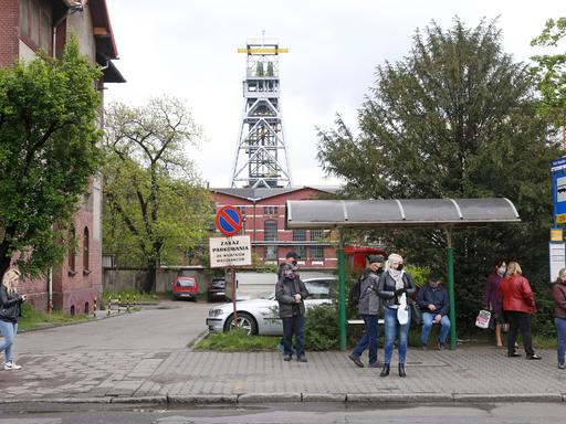 Menschen warten an der Bushaltestelle vor dem Bergwerk Bobrek (Archivbild)