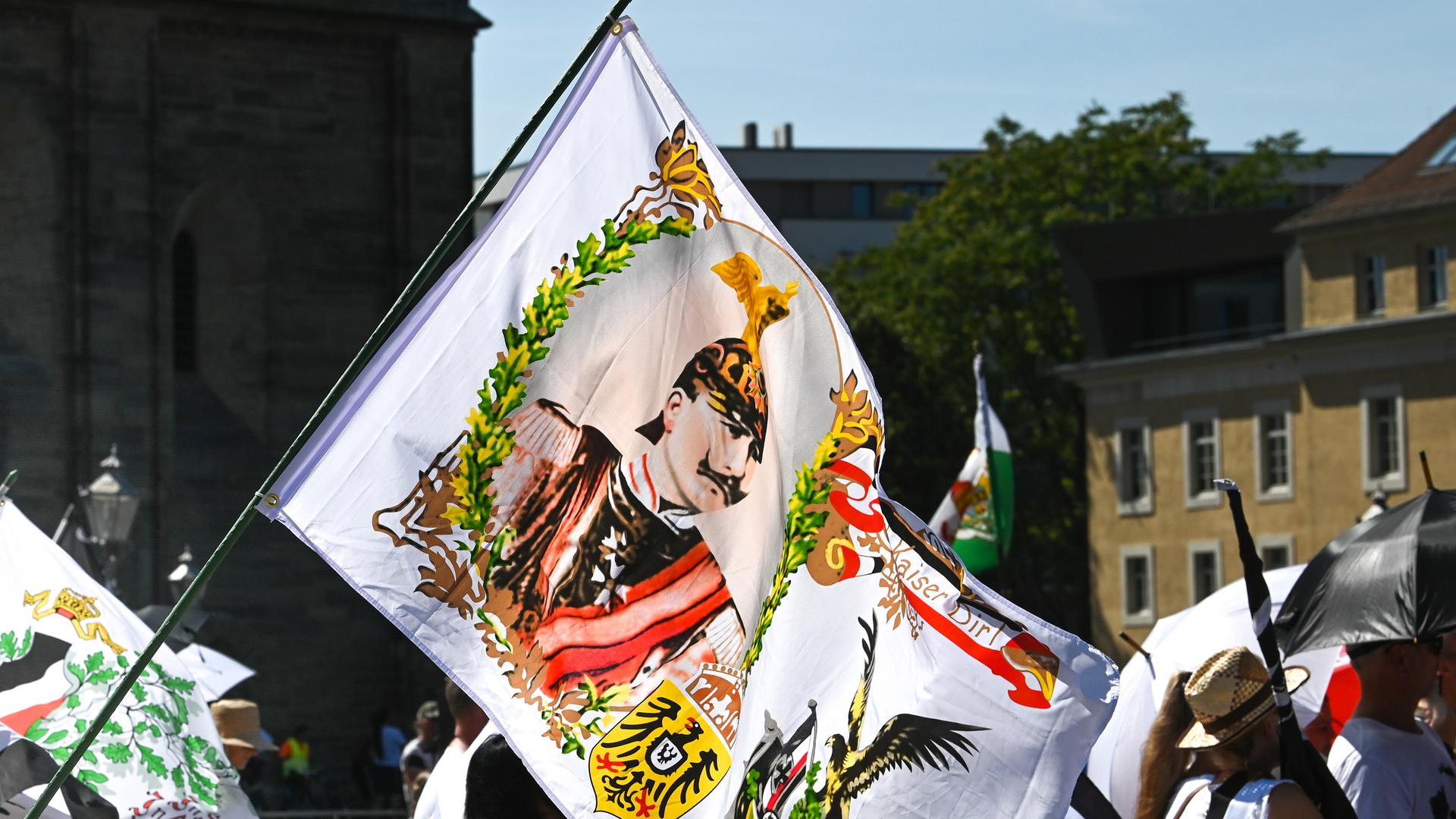 Ein Teilnehmer der Reichsbürgerdemonstration hält eine Fahne mit einem Kaiserabbild. Zur Demonstration der "Reichsbürger"-Szene waren die Teilnehmer aus der gesamten Bundesrepublik angereist.
