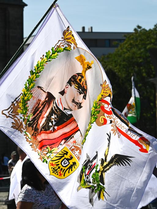 Ein Teilnehmer der Reichsbürgerdemonstration hält eine Fahne mit einem Kaiserabbild. Zur Demonstration der "Reichsbürger"-Szene waren die Teilnehmer aus der gesamten Bundesrepublik angereist.