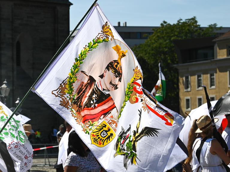 Ein Teilnehmer der Reichsbürgerdemonstration hält eine Fahne mit einem Kaiserabbild. Zur Demonstration der "Reichsbürger"-Szene waren die Teilnehmer aus der gesamten Bundesrepublik angereist.