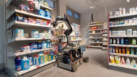 Roboter in einer Einkaufs-Labor-Umgebung greift in ein Regal.