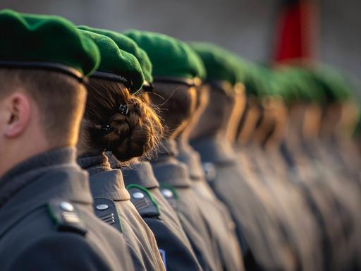 Soldatinnen und Soldaten des Wachbataillons der Bundeswehr stehen in einer Reihe. Man sieht nur die Hinterköpfe. 