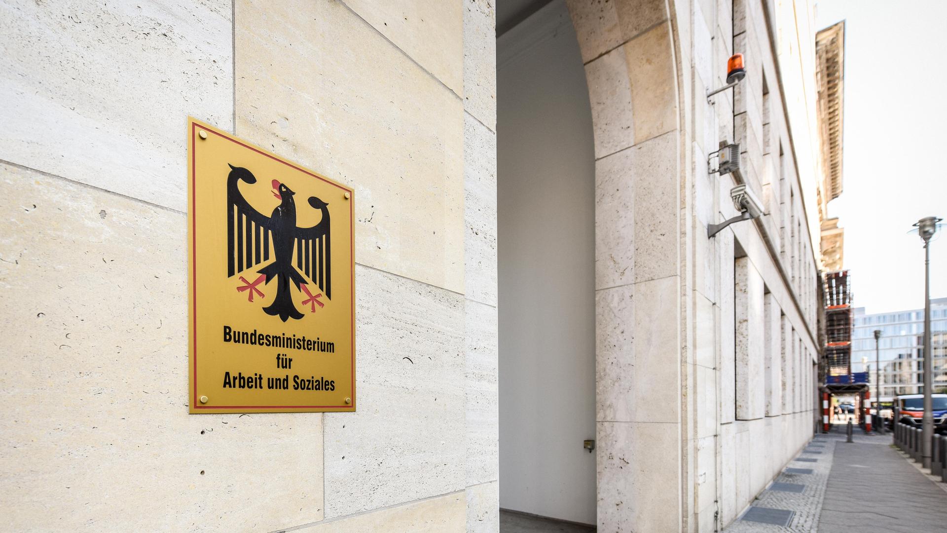 Schild mit Bundesadler an der Fassade des Bundesministeriums für Arbeit und Soziales in Berlin