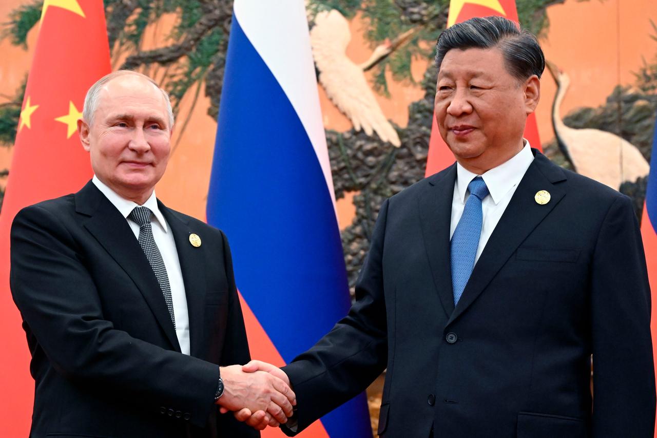 Russlands Präsident Putin und sein chinesischer Amtskollege Xi schütteln sich die Hand.