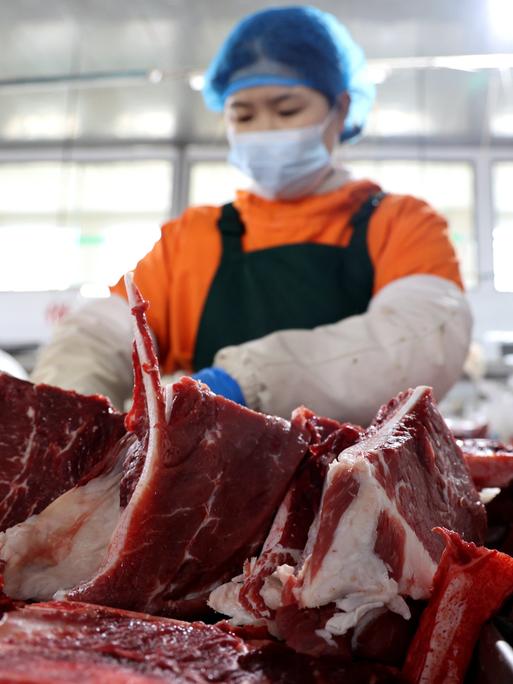 Eine Arbeiterin zerteilt Rindfleisch in der Schlachterei eines rindfleischverarbeitenden Unternehmens in Binzhou, Ostchinas Provinz Shandong.