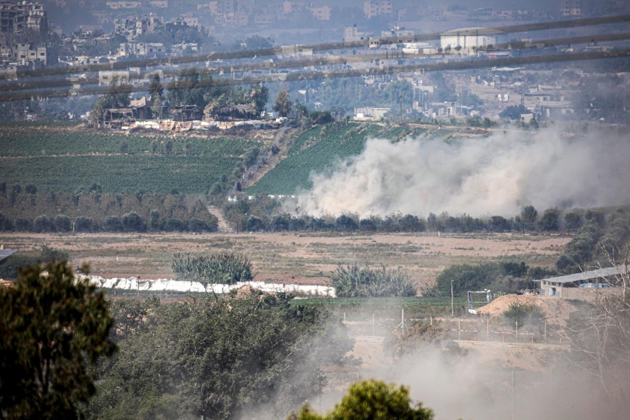 Zu sehen sind mehrere Felder im Gazastreifen, an einem Hang im Hintergrund steigt Rauch auf.
