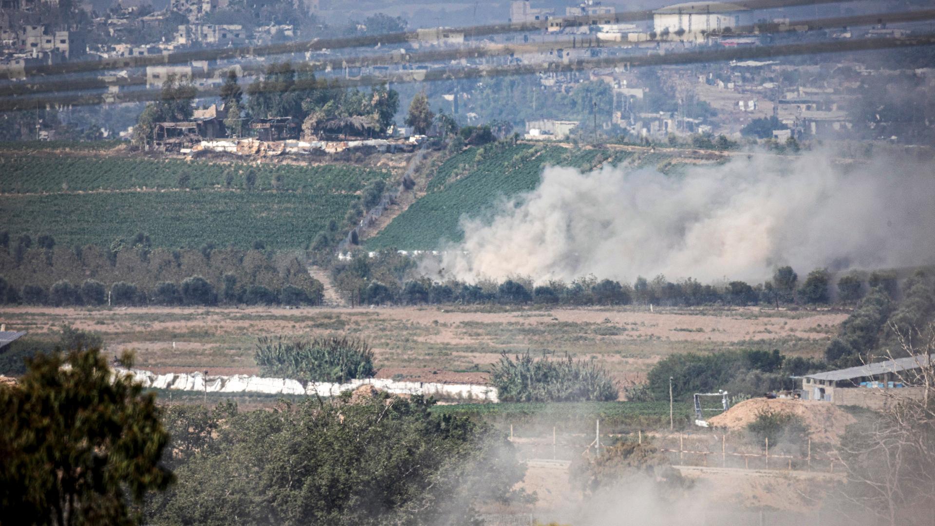 Zu sehen sind mehrere Felder im Gazastreifen, an einem Hang im Hintergrund steigt Rauch auf. Zu sehen sind mehrere Felder im Gazastreifen, an einem Hang im Hintergrund steigt Rauch auf.