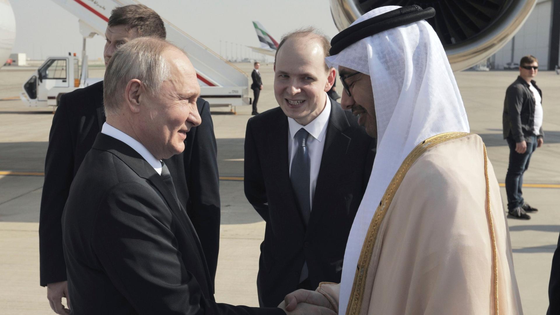 Vereinigte Arabische Emirate, Abu Dhabi: Abdullah bin Zayid Al Nahyan (r), Außenminister der Vereinigten Arabischen Emirate, der Wladimir Putin, Präsident von Russland, bei seiner Ankunft am internationalen Flughafen in Abu Dhabi begrüßt.