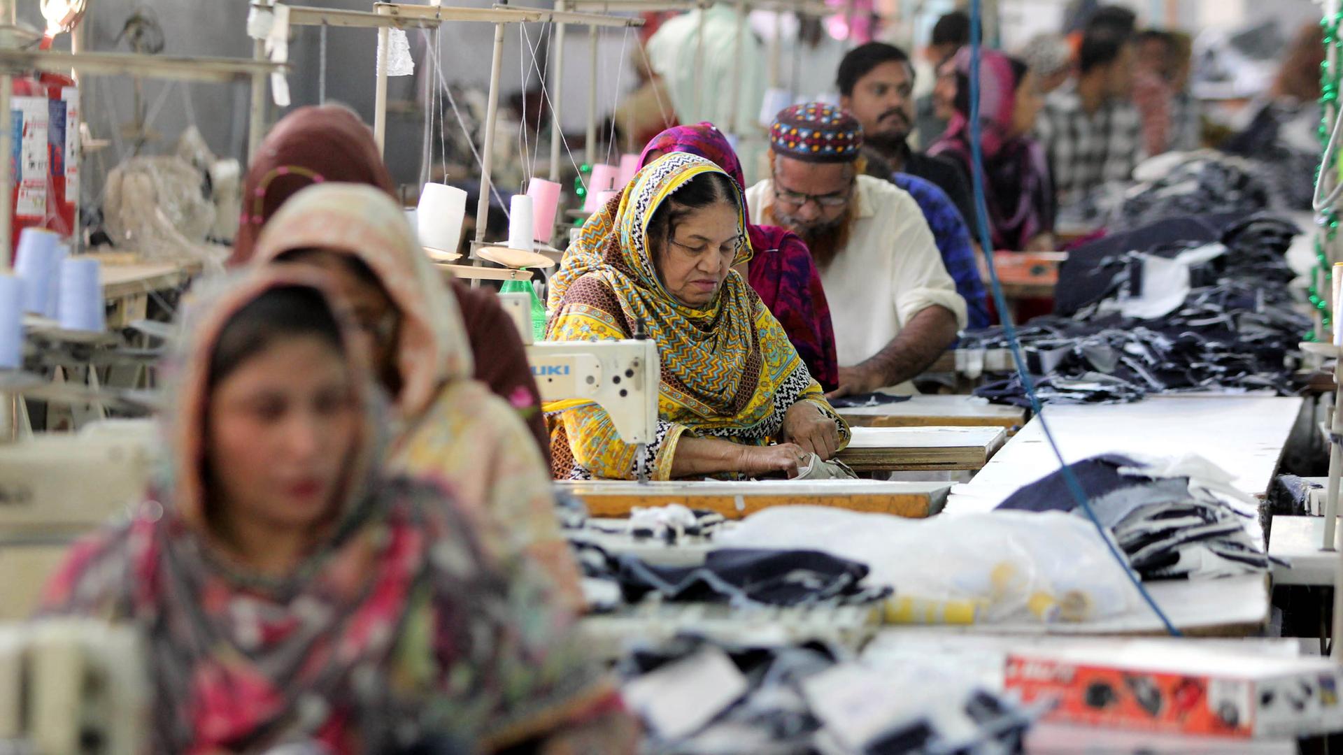 Arbeiter in einer Textilfabrik im pakistanischen Karatschi nähen Jeans.
