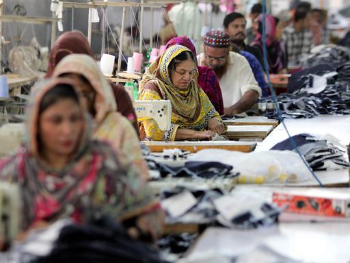 Arbeiter in einer Textilfabrik im pakistanischen Karatschi nähen Jeans.