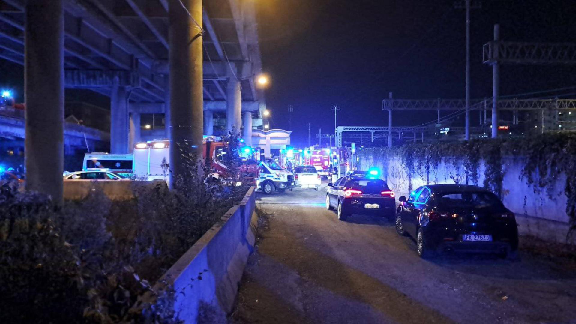 Unter einer Brücke stehen zahlreiche Einsatzfahrzeuge der Feuerwehr und der Polizei mit Blaulicht.