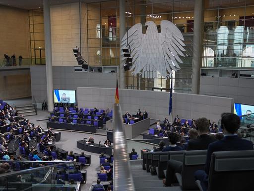 Der ukrainische Präsident Wolodymyr Selenskyj spricht auf Videoleinwänden im Bundestag.