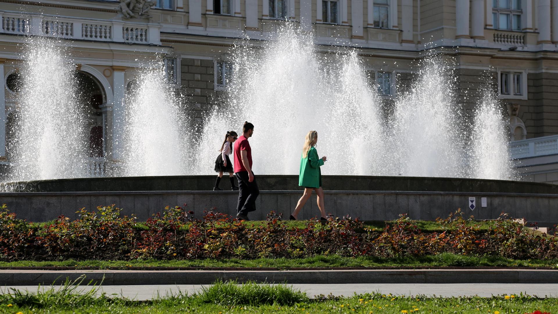 Menschen laufern an einem Springbrunnen in Odessa vorbei