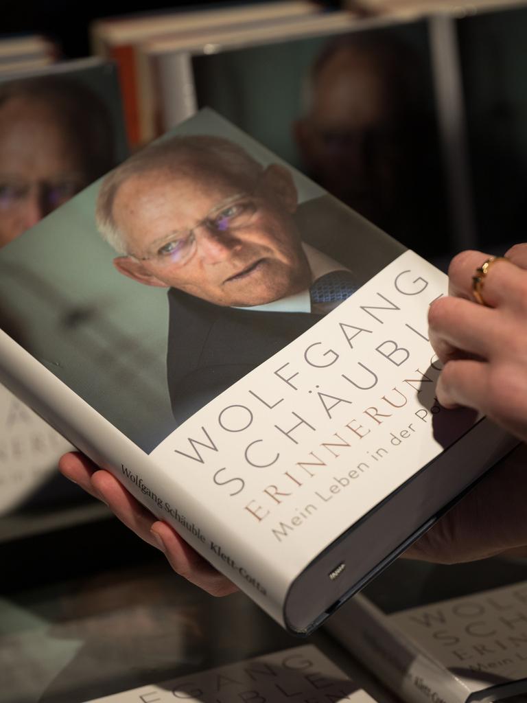 zwei Hände halten eine Ausgabe des Buches "Erinnerungen" des verstorbenen Politikers Wolfgang Schäuble in der Hand