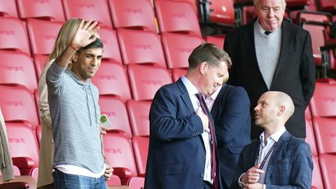 Der britische Premierminister Rishi Sunak winkt während des Premier League-Spiels im St. Marys Stadium in Southampton von der Tribüne.