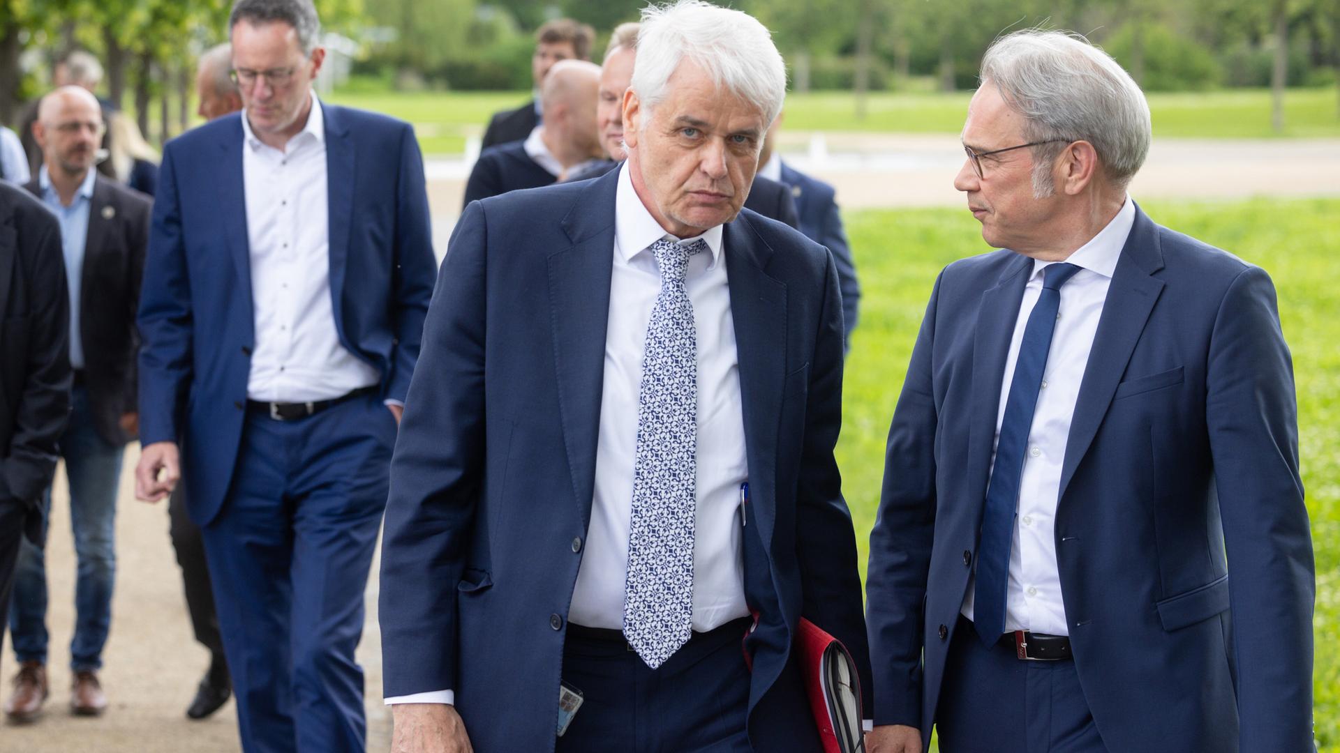 Wolfgang Schmülling, Staatssekretär im Innenministerium in Mecklenburg-Vorpommern, vorne i.d. Mitte, geht mit mehreren Personen einen Weg entlang. (Archivbild)