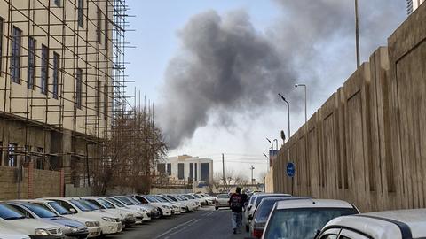 Hinter einer Häuserzeile in der iranischen Hauptstadt Teheran steigt eine dichte Rauchsäule auf.