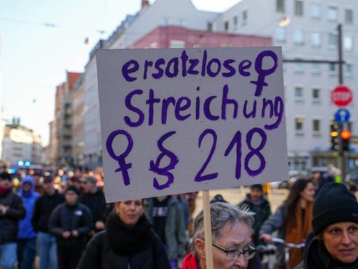 Demonstration am Internationalen Frauentag in Augsburg: Eine Frau trägt ein Schild mit der Aufschrift "Ersatzlose Streichung § 218". Das ist der Pragraph im deutschen Strafrecht zum Schwangerschaftsabbruch.
