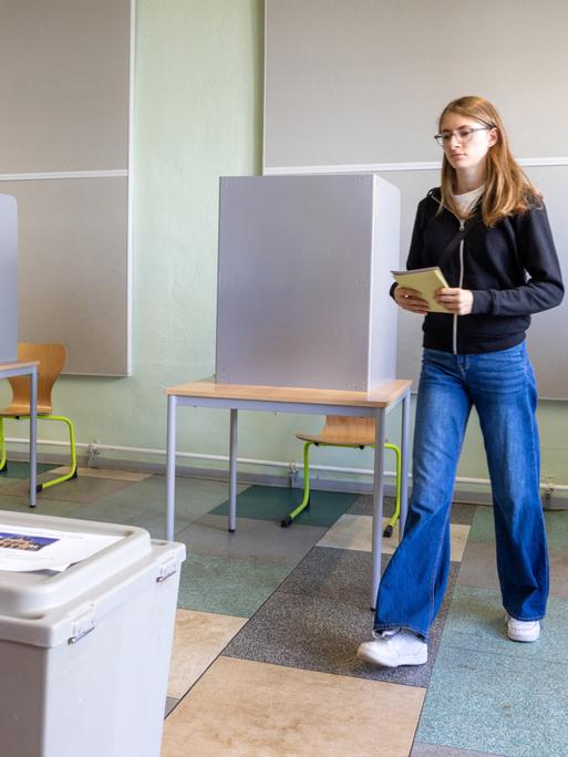 Eine 16-Jährige gibt bei den Kommunalwahlen in Thüringen in einem Wahllokal ihre Stimme ab.