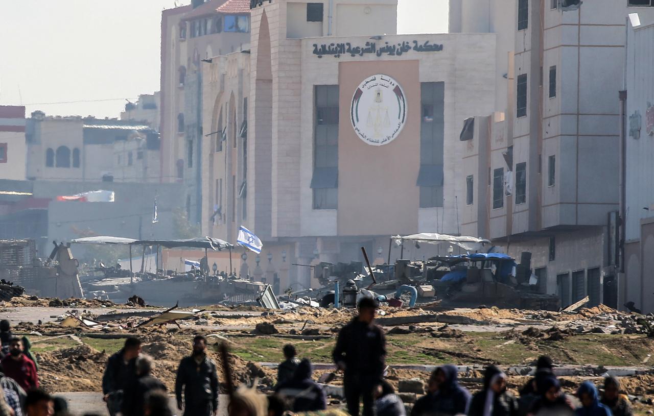 Israelische Panzer rollen an beschädigten Gebäuden in der Stadt Chan Junis im Gazastreifen entlang, während Palästinenser durch den westlichen Ausgang der Stadt in sicherere Gebiete fliehen.