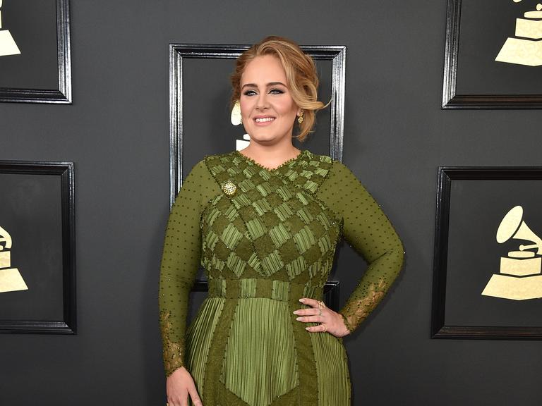 Die Sängerin Adele, sie trägt ein grünes Kleid. 