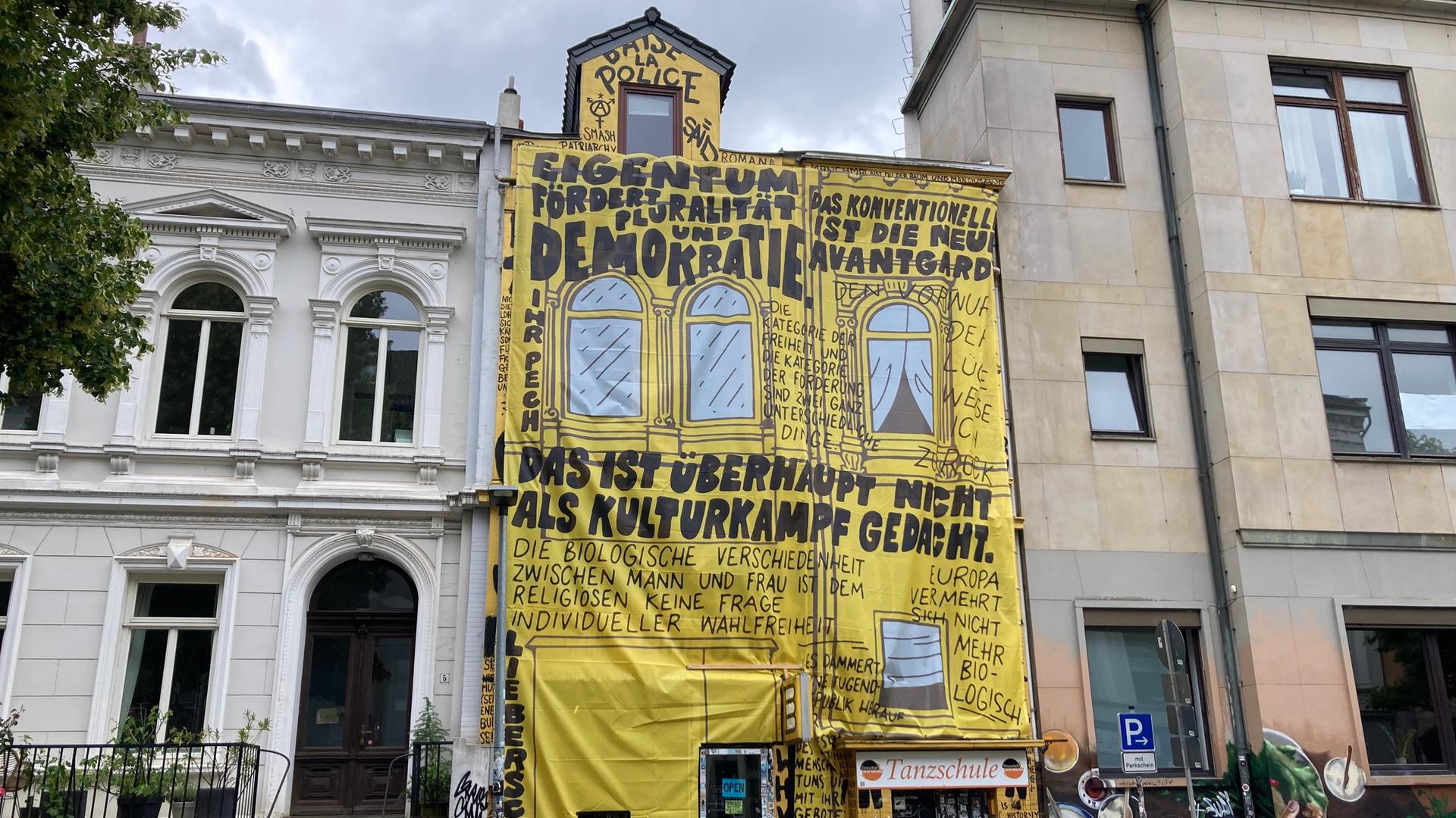 Die Buchhandlung "Golden Shop" hat ihre Fassade neu gestaltet. Auf gelbe Stoffbahnen sind Zitate von Kulturstaatsminister Weimer gedruckt, der den Laden von der Liste der Preisträger für den Deutschen Buchhandlungspreis 2026 gestrichen hatte. Die Buchhandlung "Golden Shop" hat ihre Fassade neu gestaltet. Auf gelbe Stoffbahnen sind Zitate von Kulturstaatsminister Weimer gedruckt, der den Laden von der Liste der Preisträger für den Deutschen Buchhandlungspreis 2026 gestrichen hatte.