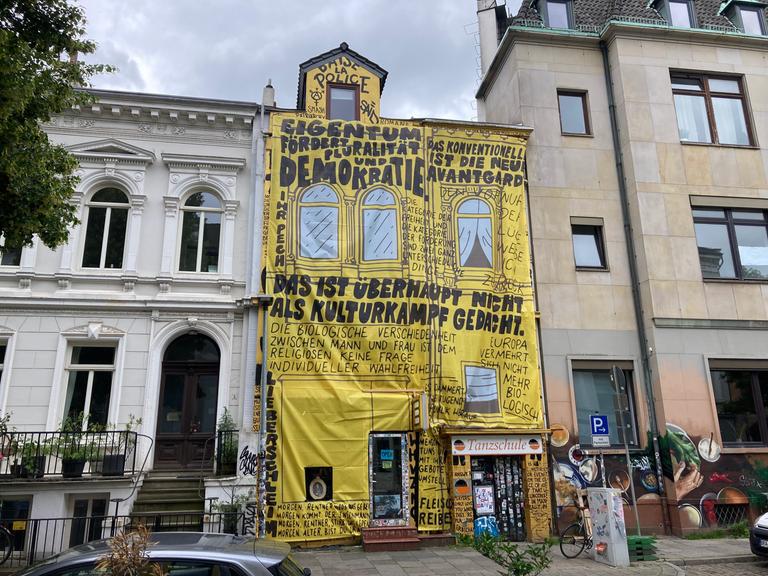 Die Buchhandlung "Golden Shop" hat ihre Fassade neu gestaltet. Auf gelbe Stoffbahnen sind Zitate von Kulturstaatsminister Weimer gedruckt, der den Laden von der Liste der Preisträger für den Deutschen Buchhandlungspreis 2026 gestrichen hatte. 