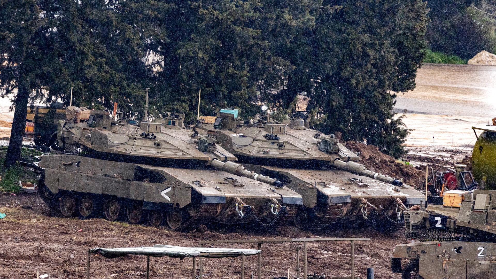 Israelische Panzer stehen auf einem matschigen Feld in der Nähe der Grenze zum Libanon. Israelische Panzer stehen auf einem matschigen Feld in der Nähe der Grenze zum Libanon.