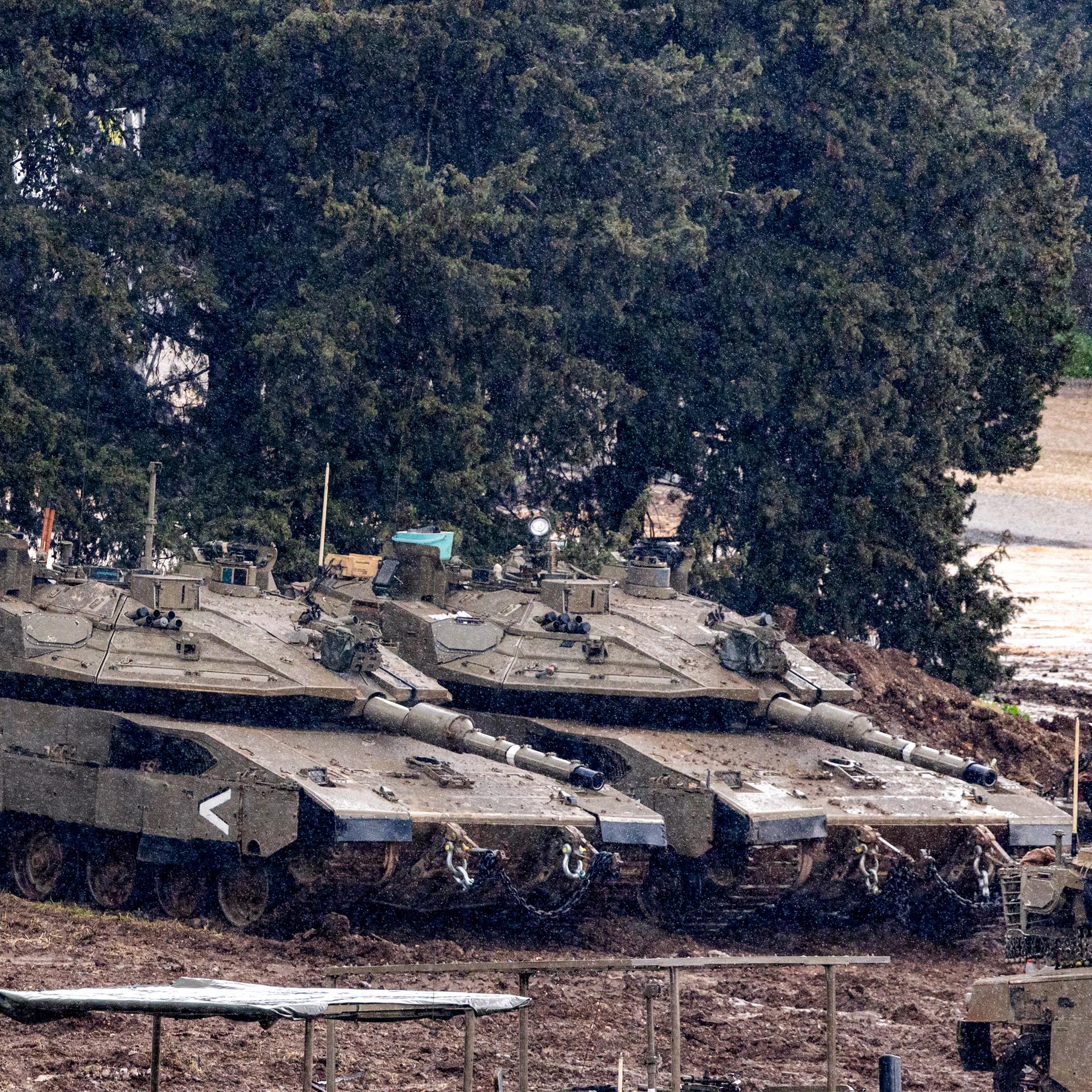 Israelische Panzer stehen auf einem matschigen Feld in der Nähe der Grenze zum Libanon.