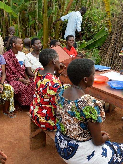 Eine Gruppe von Leuten spricht in einem Dorf bei Cankuzo im Norden von Burundi über Mikrokredite.