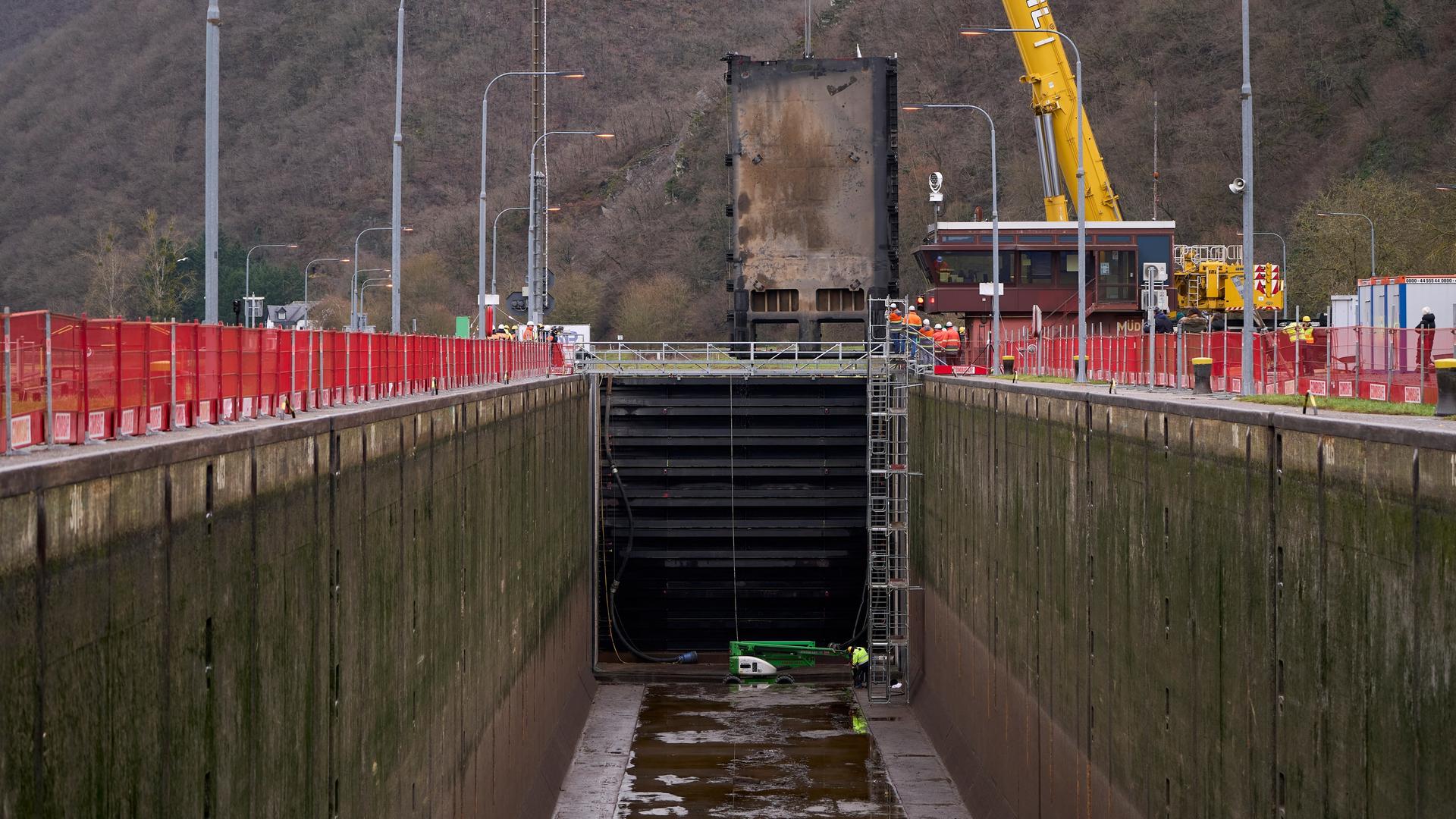 Ein Kran setzt das zwei tonnenschweren Ersatztor in die beschädigte Mosel-Schleuse ein. 