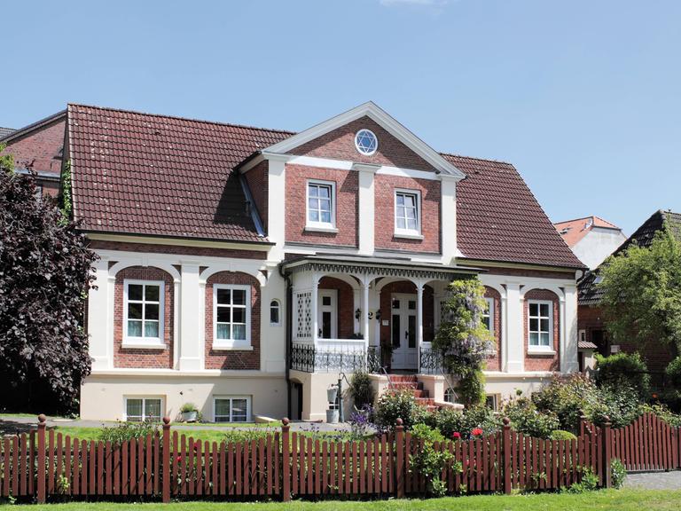Ein Einfamilienhaus mit Veranda und einem Garten (Symbolbild)