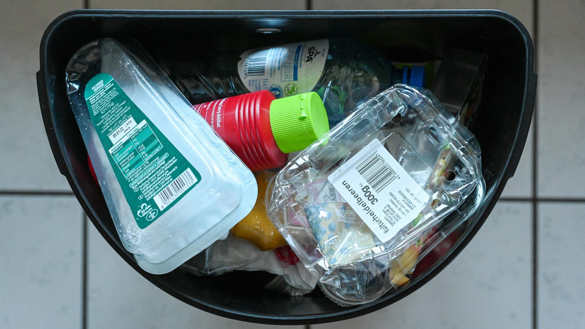 Ein Mülleimer ist mit verschiedenen Verpackungen aus Plastik gefüllt.