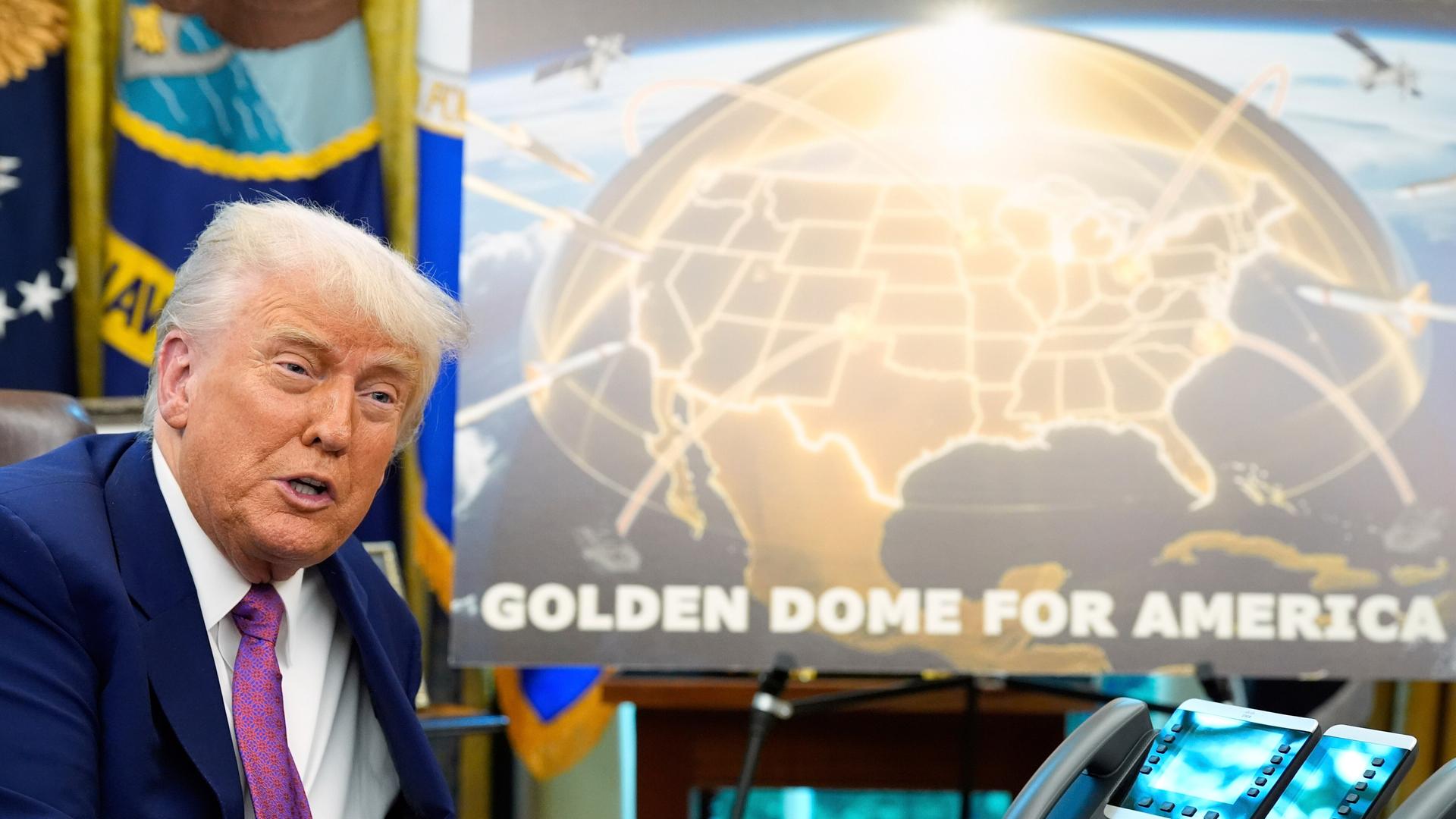 US-Präsident Donald Trump sitzt im Oval Office vor Poster mit "Golden Dome" (20.3.2025) 