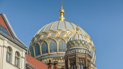 Synagoge in der Oranienburger Straße in Berlin-Mitte. Die goldverzierte Kuppel glänzt im Sonnenschein vor strahlend blauem Himmel