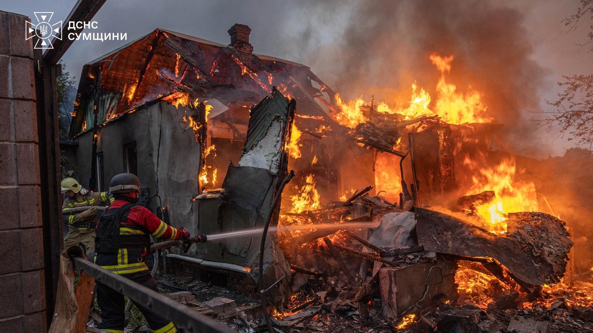 Ukraine, Sumy: Auf diesem Foto, das vom ukrainischen Rettungsdienst zur Verfügung gestellt wurde, löschen Feuerwehrleute nach einem russischen Luftangriff einen Brand in Privathäusern. 