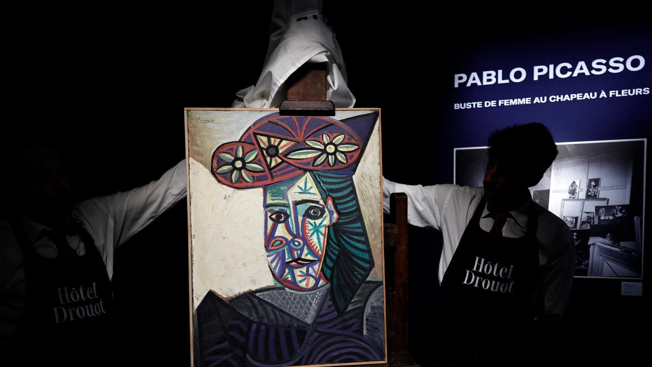 Mitarbeiter enthüllen am 18. September 2025 im Auktionshaus Hotel Drouot ein Gemälde des französischen Künstlers Pablo Picasso mit dem Titel „Büste einer Frau mit geblümtem Hut“, das eine seiner Geliebten, Dora Maar, zeigt.