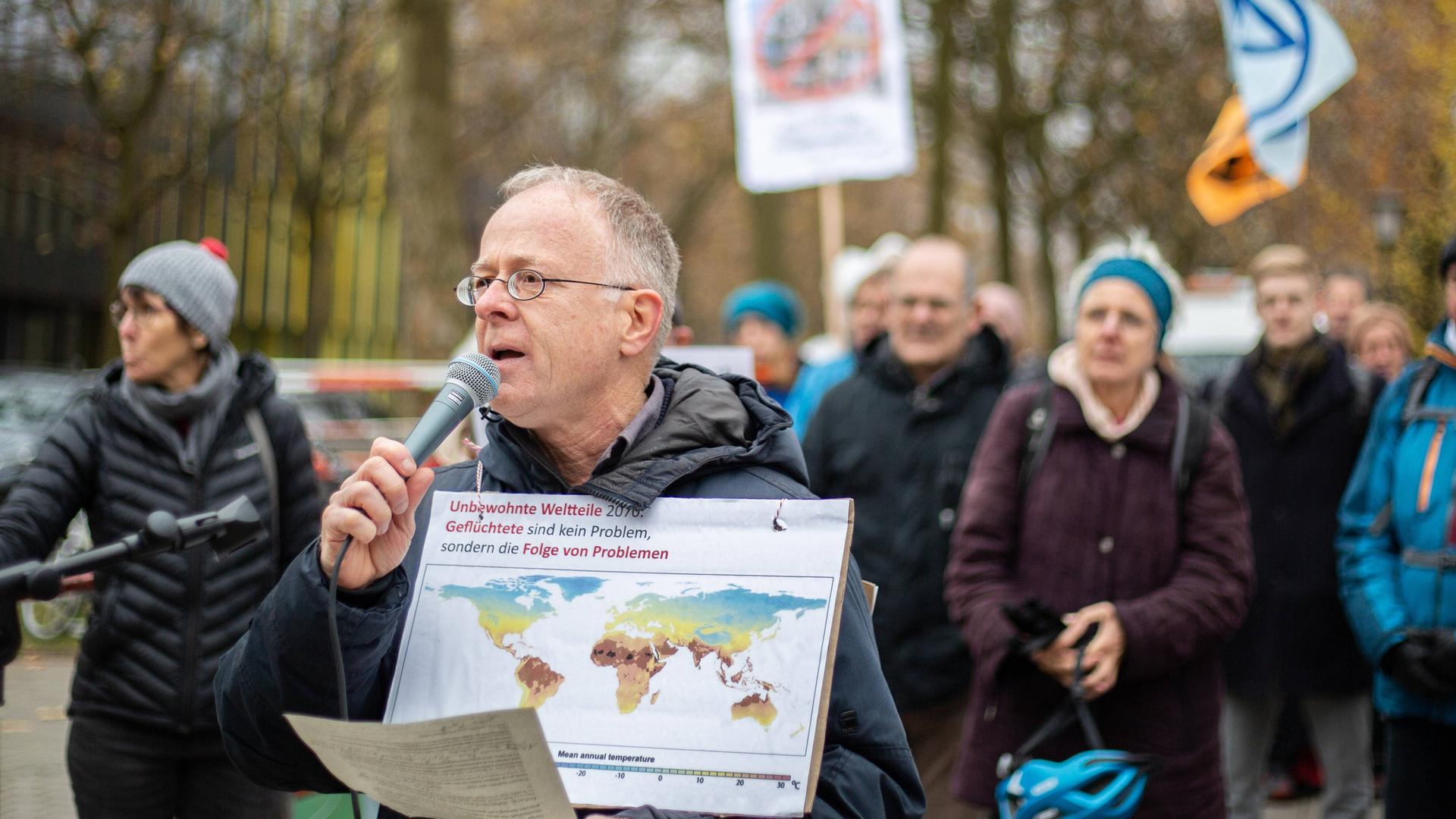 Jörg Alt spricht bei einer Demo vor dem Tagungshotel der Innenministerkonferenz in Solidarität mit der Letzten Generation und für Klimaschutz in München in ein Mikrofon.