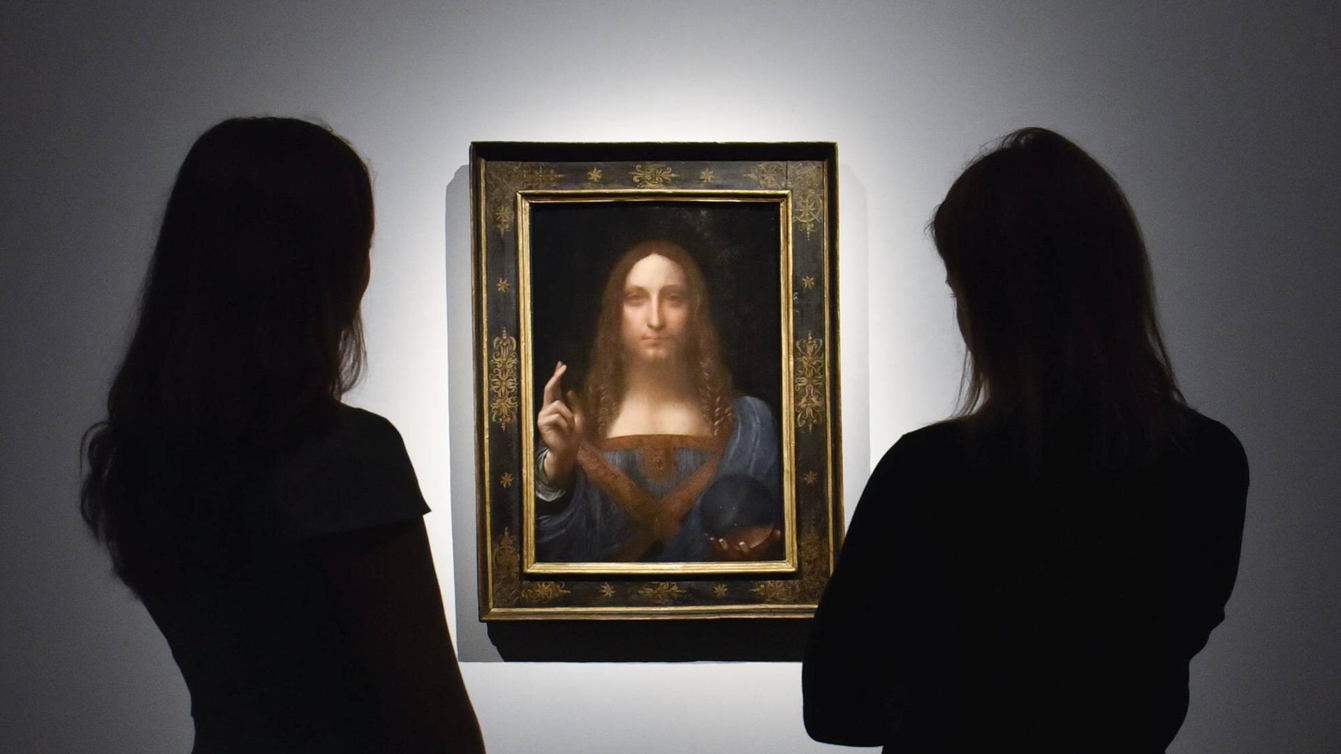 Zwei Mitarbeiterinnen vor dem Gemälde "Salvator Mundi", das Leonardo da Vinci zugeschrieben wird, am 24.10. 2017 bei Christie's in London.