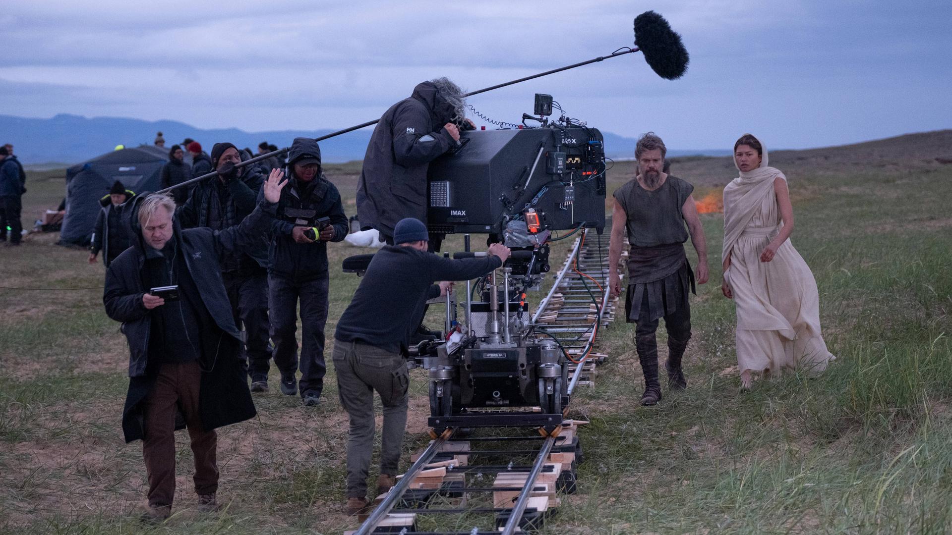Regisseur Christopher Nolan (links) mit Schauspieler Matt Damon als Odysseus und Zendaya als Athene am Set seines Films „Die Odyssee“, bei dem Christopher Nolan für Drehbuch, Produktion und Regie verantwortlich ist. Regisseur Christopher Nolan (links) mit Schauspieler Matt Damon als Odysseus und Zendaya als Athene am Set seines Films „Die Odyssee“, bei dem Christopher Nolan für Drehbuch, Produktion und Regie verantwortlich ist.